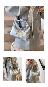 Detailansicht der silbernen Metallic-Handtasche mit Schleife und rundem Tragegriff