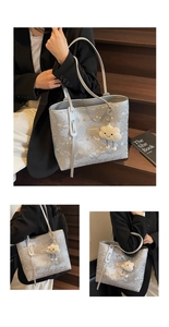 Detail of silver snake-pattern tote bag with long tassels and plush cloud charm