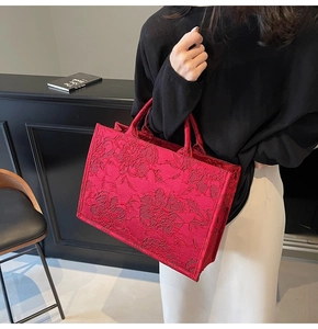 Detail of red floral jacquard fabric and texture on a large wedding tote bag