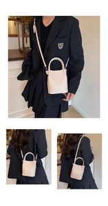 Macro view of beige lychee texture bucket bag with round handle and shoulder strap