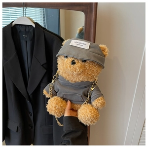 Detail of cute teddy bear plush crossbody bag with grey hoodie and gold metal chain