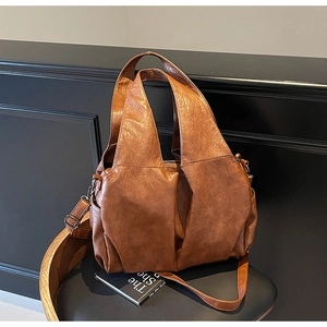 Detail of vintage brown tote bag showing supple leather texture and adjustable strap