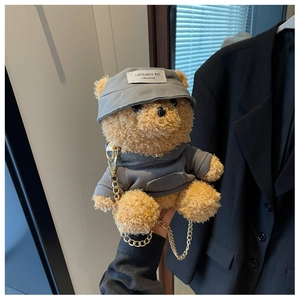 Detail of plush teddy bear bag wearing a grey hoodie and stylish gold chain strap
