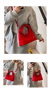 Detail der roten Handtasche mit Schleife, Silberakzenten und Schultergurt an einem Model