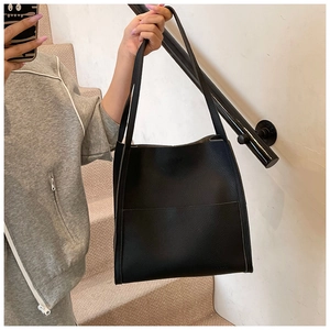 Detail of minimalist black lychee grain leather tote bag with a spacious interior design