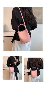 Detail view of pink leather bucket bag with lychee texture and adjustable shoulder strap
