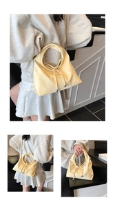 Detailansicht der cremefarbenen Handtasche mit Schleife, Rundgriff und Silberperlen