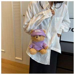 Detail of plush teddy bear crossbody bag with purple hoodie and golden chain strap