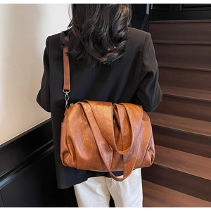 Detail of caramel large capacity shoulder bag showing pleated faux leather texture and straps
