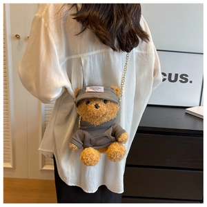 Close-up of cute plush teddy bear bag in brown faux fur wearing a grey hoodie and cap
