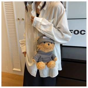 Detail of brown plush bear crossbody bag with grey hoodie and gold metal chain strap