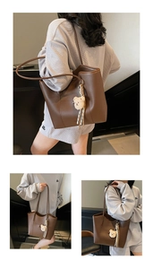 Detailed view of brown matte leather tote bag with bear charm and double straps