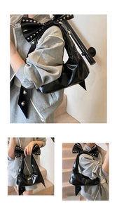 Detail der großen Schleife mit silbernen Nieten an der schwarzen Lackleder-Tasche