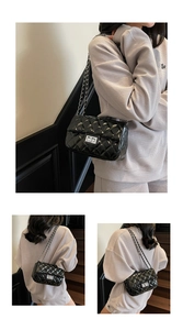 Detail of glossy quilted crossbody bag with silver chain strap and turn-lock closure