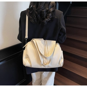 Detail of minimalist cream oversized tote bag showing wrinkled leather texture on shoulder