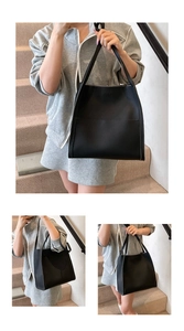 Close-up of black lychee grain leather tote bag showing texture and dual shoulder straps