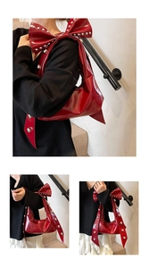 Detail der roten Lackledertasche mit silbernen Nieten und großer Schleife