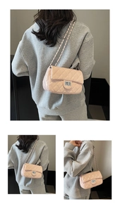 Detailed view of pink quilted crossbody bag with silver twist lock and chain strap