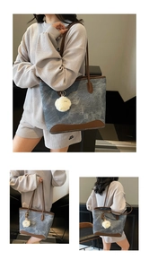 Vista macro della borsa tote in denim blu con finiture in pelle marrone e charm
