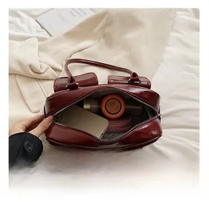 Macro view of the internal storage and zip closure of a glossy dark red tote bag