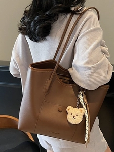 Large dark brown vintage tote bag with plush bear charm and woven rope decoration