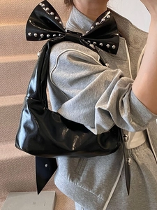 Sac fourre-tout en cuir verni noir avec nœud et rivets pour un look urbain chic