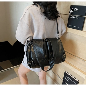 Model view of a large black tote bag with wrinkled texture and stylish shoulder strap