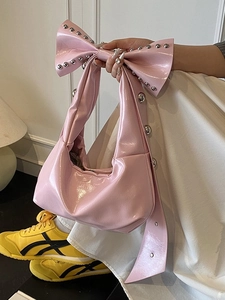 Sac à main rose en forme de nœud avec clous argentés et finition brillante