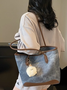 Grande borsa tote in tela grigia con finiture in pelle marrone e ciondolo a pompon