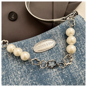 Detail of glitter denim crossbody bag with large faux pearls and floral metal chain