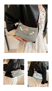 Detail of denim shoulder bag with pink piping, pearl chain and silver bow charm