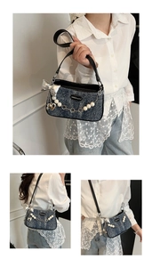 Detail of blue denim hobo bag with pearl chain and silver bow charms for women