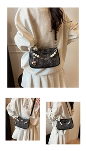 Detail of black sequin crossbody bag featuring pearl chain and heart pendant ornaments