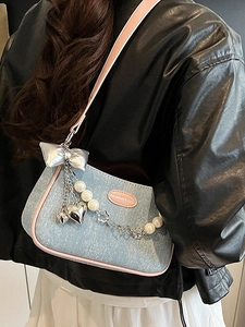 Denim shoulder bag with pearl chain and pink trim, worn with black leather jacket