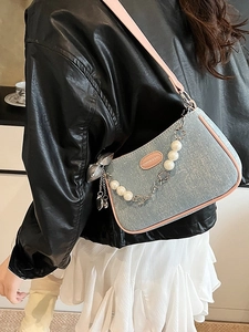 Light blue polka dot denim hobo bag with pink leather trim and decorative pearl chain