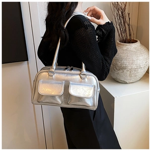Detail of silver metallic tote bag featuring dual front pockets and shoulder straps