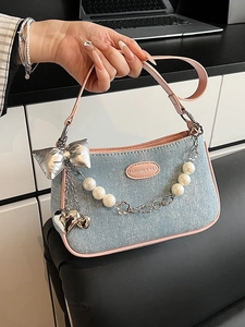 Blue denim crossbody handbag with pink trim, pearl chain, and butterfly charm