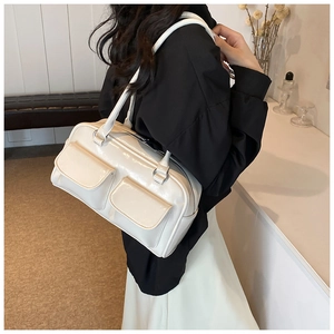 Detailed back view of a white glossy faux leather shoulder bag worn by a model