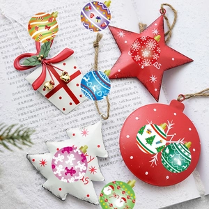 Détail de suspensions de Noël en métal avec formes d'étoiles et de sapins sur un magazine