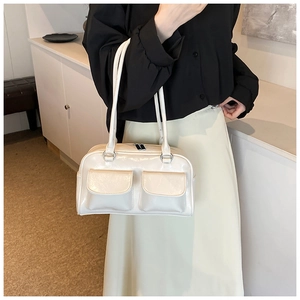 Close-up of a white patent leather shoulder bag with silver hardware and dual flap pockets