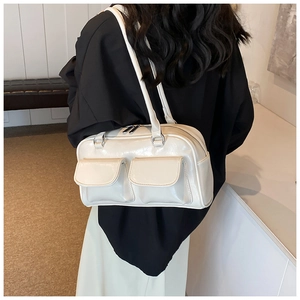 Close-up of minimalist cream white glossy PU tote bag worn as a stylish underarm shoulder bag