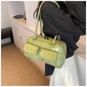 Detail of avocado green patent leather underarm bag with double front flap pockets