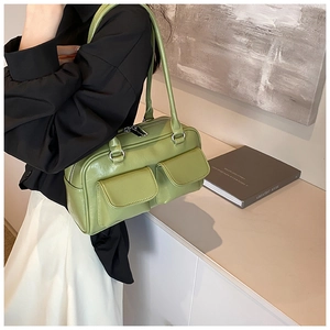 Detail of avocado green baguette bag with dual flap pockets and silver zipper