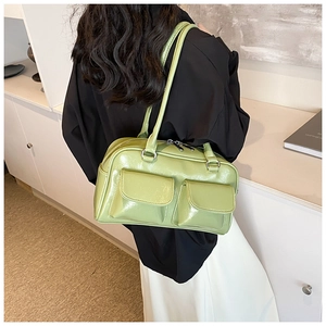 Close-up of light green patent leather shoulder bag with dual front flap pockets