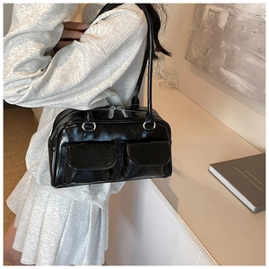 Detail of black glossy tote bag with dual front pockets and polished silver hardware