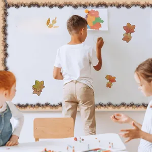 Autumn-themed bulletin board border with maple leaf stickers shown in a classroom setting