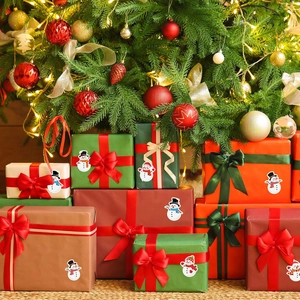 Christmas snowman self-adhesive stickers on gift boxes with a festive tree background