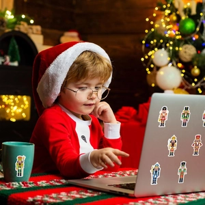 Autocollants de casse-noisettes décorant un ordinateur et une tasse dans une scène de Noël