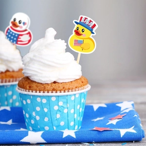 Patriotic duck cupcake toppers with USA flag elements on white cream desserts