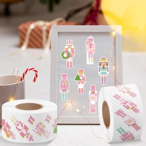 Rouleau d'autocollants casse-noisette rose avec motifs de Noël sur fond de bois blanc